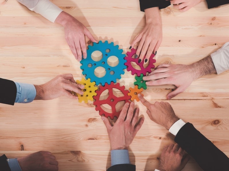 Business people with gears on the table