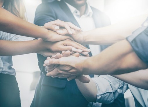 Co-workers stacking their hands atop of each other